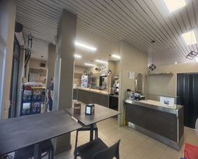 Interno della Pizzeria al taglio Da Alex con tavoli e ospiti